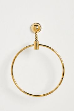 a gold plated metal towel ring on a white background