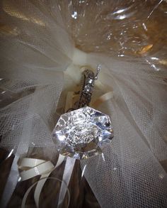 a diamond ring sitting on top of a white tulle