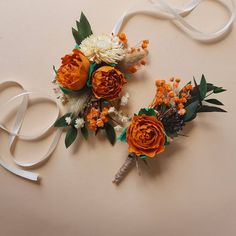 two orange and white flowers are tied together