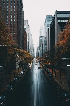 an empty city street with tall buildings on both sides