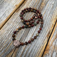 Beautiful Red Creek Jasper and Copper Necklace with an Antiqued Copper Circle Pendant: Beads: * Red Creek Jasper  -  4mm * Copper Spacer Beads - 1mm Pendant: *Antique Copper Circle Pendant  - 10.8mm Clasp: *Copper Lobster Claw Clasp  Model is wearing 15 inches Choose Length at checkout. Extender chains also available! To view more of my original jewelry designs, visit: https://www.etsy.com/shop/TheBeadCounter Bohemian Jasper Necklace For Gift, Red Jasper Spiritual Necklace, Nature-inspired Brown Jewelry With 8mm Beads, Earthy Jasper Beaded Necklace For Gift, Earthy Jasper Beaded Necklace As Gift, Rustic Brown Jewelry With 8mm Beads, Spiritual Jasper Jewelry For Meditation, Artisan Jasper Beaded Necklaces As Gifts, Spiritual Copper Beaded Necklaces As Gift