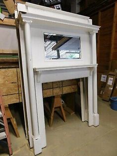 a white fireplace in a room with lots of wood