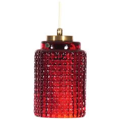 a red glass light hanging from a ceiling