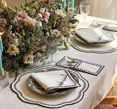 a table set with place settings and flowers