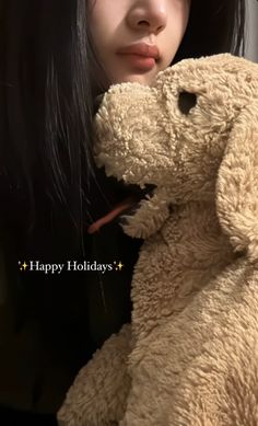 a woman holding a teddy bear in front of her face with the caption happy holidays