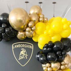 black and gold balloons are on display in front of a lamb logo sign that reads lamborgshin