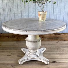 an old white table with a potted plant on top