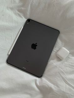 an apple ipad is sitting on a white sheet