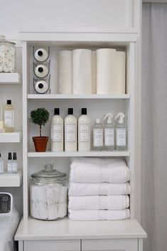 the shelves in this bathroom are filled with white towels and toiletries, all stacked on top of each other