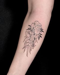 a black and white flower tattoo on the right arm, with leaves around it's edges