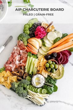 a platter filled with lots of different types of vegetables and fruits on top of a white table