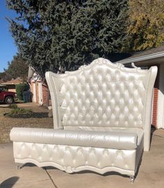 a white couch sitting on top of a sidewalk