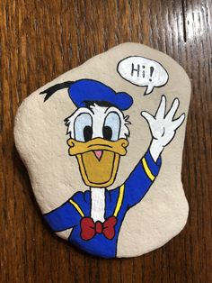 a painted rock with an image of donald duck on it