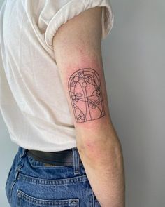 a woman's arm with a tattoo on it that has an image of a man in a window