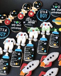 some cookies that are decorated to look like space shuttlers and rockets, with the words it's a boy on them