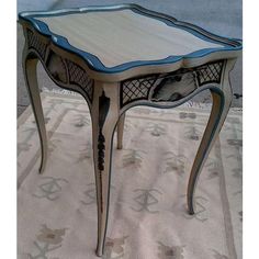 a white table with blue trim on it sitting on top of a carpeted floor