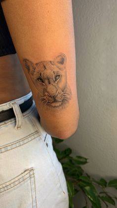 a woman's arm with a tattoo of a lion on it