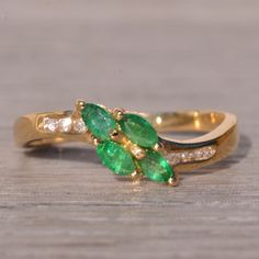 The Rast: Emerald And Natural Diamond Ring In Yellow Gold. This Elegant Ring Features Four Marquise Brilliant-Cut Natural Emeralds, Artfully Set At An Angle At The Center, Complemented By A Sweeping Shank. Enhancing The Design, Three Round Brilliant-Cut Natural Diamonds Are Channel-Set On Each Side Of The Center, With A Total Weight Of 0.06 Carats. Crafted In 14 Karat Yellow Gold, This Stunning Piece Is Currently A Finger Size 6.5, With The Option To Adjust To Any Finger Size For An Additional Charge Upon Request, Ensuring A Perfect Fit For Your Unique Style. Natural Diamond Ring, Elegant Ring, Channel Set, Natural Emerald, Round Brilliant Cut, Womens Jewelry Rings, Round Brilliant, Natural Diamonds, Unique Style