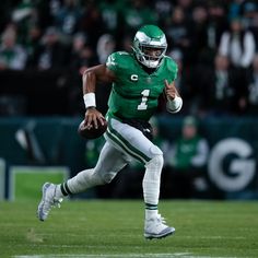 a football player running with the ball in his hand and people watching from the stands