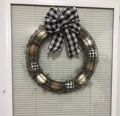 a wreath is hung on the front door with a black and white checkered bow