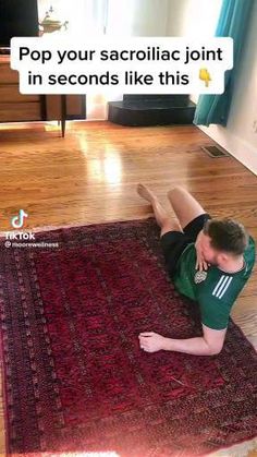 a man laying on top of a red rug