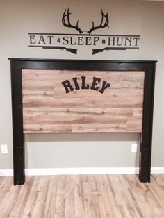 the headboard is made out of wood and has an antelope hunt sign on it