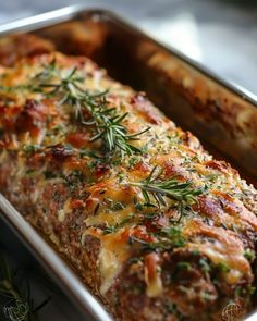 a casserole dish with meat, cheese and herbs