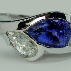 a blue and white ring with two pear shaped diamonds