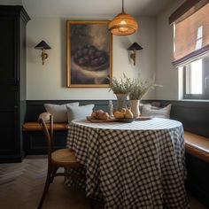 a dining room table with a checkered cloth on it and some fruit in the bowl