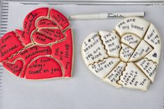 two heart shaped cookies with writing on them next to a marker and paper clipping