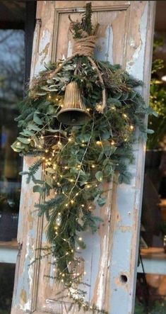 an old door is decorated with greenery and lights