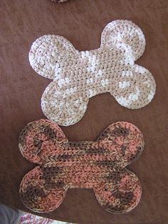 three crocheted dog bone shaped rugs on top of a brown tablecloth