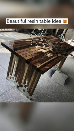 a table made out of wooden planks sitting on top of a cement floor next to a sidewalk