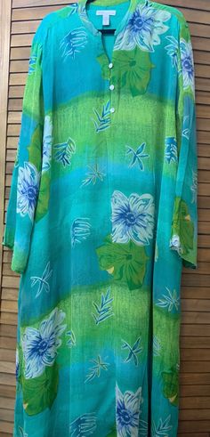 This Studio by Valerie Stevens garment is a beautiful shades of green summer dress/Kaftan in size 3X  This beautiful fully lined Kaftan/long dress in shades of green is perfect to be a beach/pool coverup or a dress for a casual summer event.  Features include a wispy shell with stylized flowers on a variegated green background.  The garment is lined except for the sleeves, has front buttons to below the chest, long sleeves, mandarin collar, and dual side vents in both the shell and the lining. Turquoise Maxi Dress For Beach Cover-up, Casual Green Dress For Beach Cover-up, Green Tunic Cover-up For Spring, Spring Green Tunic Cover-up, Green Spring Tunic Cover-up, Green Floral Print Vacation Dress, Green Floral Print Dress For Vacation, Green Hawaiian V-neck Dress, Green V-neck Beach Dress For Vacation