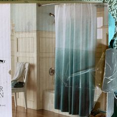 the inside of a bathroom with a shower curtain and chair in it, next to an open magazine