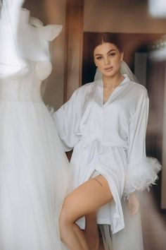 Make your wedding day morning even more special with our short silk wedding robe with feathers. Crafted from high-quality silk, this luxurious bridal robe is designed to make every bride feel elegant and comfortable as she prepares for her big day. The delicate feathers adorning the cuffs add a touch of glamour and uniqueness, making it a stunning choice for your wedding day photos.  * Length 85-90 cm / 33-35 in * Handmade * High-quality soft Armani silk * Made to measure * Feathers on buttons ( Elegant Satin Robe With Feathers, Elegant Robe With Feather Trim For Wedding Night, Elegant Wedding Robe With Feathers, Wedding Satin Robe With Feathers, Feathered Robe For Wedding Night, Satin Wedding Dress With Feather Trim, Wedding Satin Dress With Feather Trim, Elegant Satin Robe For Honeymoon, Elegant Wedding Night Dress With Feather Trim