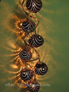 a string of lights hanging from the side of a wall in front of a green background