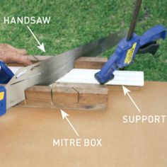 a person using a pair of scissors to cut wood with a mitre box on the table