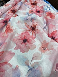 an unmade bedspread with pink flowers and blue trim on it's edges