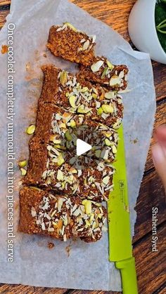 a person holding a knife over some food on top of a piece of parchment paper