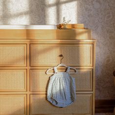 a baby's diaper hanging on a wooden dresser