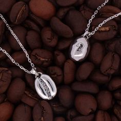 This coffee bean necklace is the result of a collaboration with our friends at Kona Coffee Purveyors in Honolulu. Our intention was to make an elevated coffee bean jewelry collection for their discerning customers, and we think we hit the mark! The pieces are solid sterling silver with oxidized details, and each one has a row of channel-set white topaz in the center. The back of the pendant has KCP's logo, the ‘Ākepa bird, which lives in the Ohia Lehua forest on the Big Island where Kona Coffee is grown. We started the project during Covid so it took an extra long time to roll out, but these pieces are finally finished and available in their beautiful cafe in Waikiki and on both of our websites. We hope everyone enjoys these pieces as much as we enjoyed designing them! Diamond cut chain is Ohia Lehua, Bean Jewelry, Golden Coffee, Beautiful Cafe, Bean Necklace, Kona Coffee, Tv Gift, The Big Island, Coffee Bean