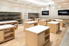 an empty room filled with lots of desks and chairs in front of large screens