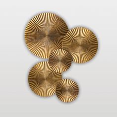 four gold fan shaped plates sitting on top of each other