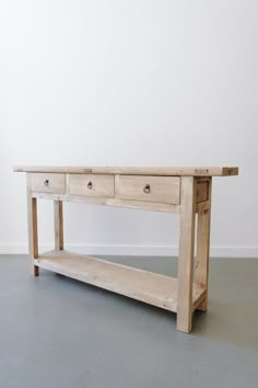 a wooden table with two drawers on one side and an open shelf on the other