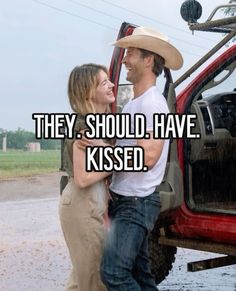 a man and woman standing in front of a red truck with the words they should have kissed