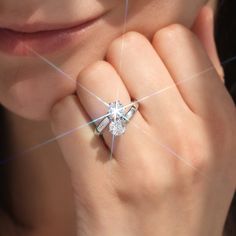 a close up of a person's hand with a ring on their finger and the light reflecting off her face