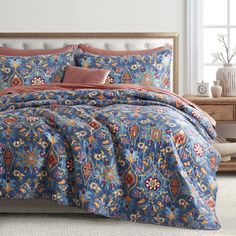 a bed with blue and orange comforter in a room