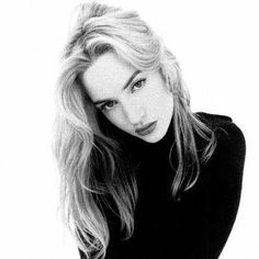 a black and white photo of a woman with long blonde hair wearing a turtle neck sweater