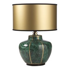 a green and gold vase lamp with a black shade on the top, against a white background